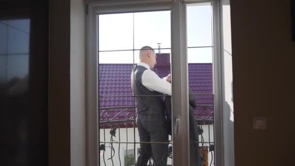 若いビジネスマン自宅でバルコニーにジャケットを着る スローモーション 高品質のフルHd映像 — ストック動画