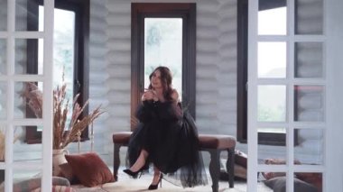 Siyahlı kadın şarkıcılar bir kanepede otururken stüdyoda bir müzik videosu hazırlıyorlar. Yüksek kalite 4k görüntü