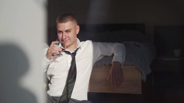 Tişörtlü Bir Adamı Yerde Oturmuş Elinde Bir Bardak Alkol Viski — Stok video