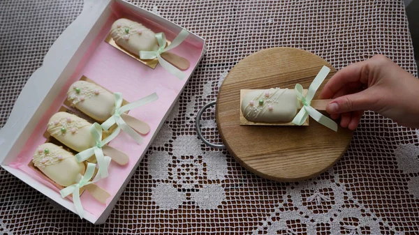 Pembe kurdele kutusunu açan kadın, arka planda dondurma şeklinde lezzetli beyaz çikolatalı cheesecake ile birlikte. Yüksek kalite 4k görüntü