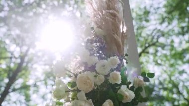 Sokaktaki Boho düğün kemeri. Kemer çiçek aranjmanları, ortancalar, gladioli ve kurumuş kamış dallarıyla süslenmiş. Bir çiçekçi tarafından yaratılmış bir düğün dekoru. Yüksek kaliteli FullHD görüntüler