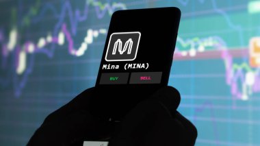 Bir yatırımcı ekranda Mina 'yı (MINA) analiz ediyor. Telefon kriptonun yatırım fiyatlarını gösteriyor.