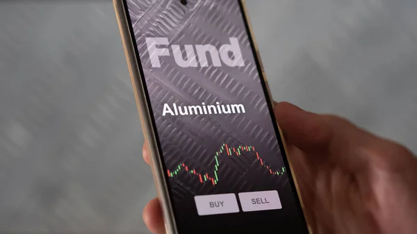 一个投资者正在屏幕上分析铝等基金 电话显示了铝金属的价格 — 图库照片