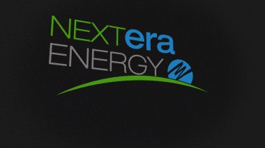 07 Eylül 2023 Juno Sahili, Florida. Beyaz ekran duvarında NextEra Enerji logosu. Bir aygıtın üzerinde NextEra Enerji damgası.