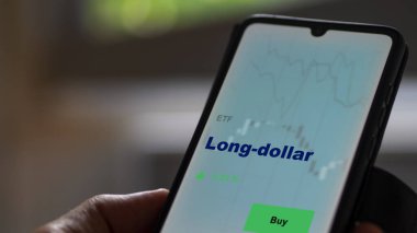 Ekrandaki uzun vadeli etf fonunu analiz eden bir yatırımcı. Uzun doların fiyatlarını gösteren bir telefon.