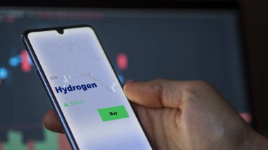 Ekranda hidrojen etf fonunu analiz eden bir yatırımcı. Hidrojen fiyatlarını gösteren bir telefon
