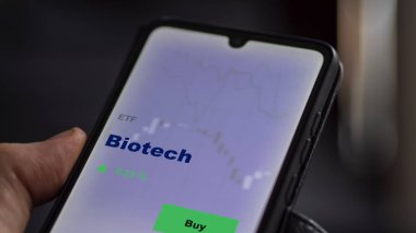 Bir yatırımcı ekranda biyoteknoloji etf fonunu analiz ediyor. Biotech 'in fiyatlarını gösteren bir telefon