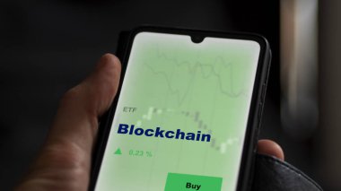 Ekrandaki engelleme fonunu analiz eden bir yatırımcı. Blockchain 'in fiyatlarını gösteren bir telefon