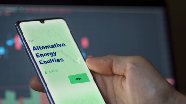 Alternatif enerji sermayelerini perdede analiz eden bir yatırımcı. Alternatif Enerji Varlıklarının fiyatlarını gösteren bir telefon