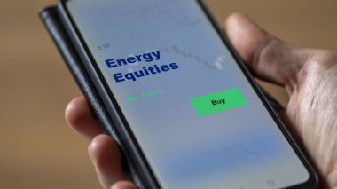 Bir yatırımcı ekrandaki enerji sermayesini analiz ediyor. Enerji Varlıkları 'nın fiyatlarını gösteren bir telefon