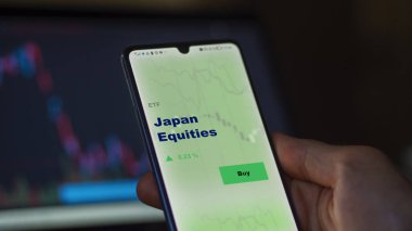 Japonya 'nın sermaye fonunu ekranda analiz eden bir yatırımcı. Japon Sermayesi 'nin fiyatlarını gösteren bir telefon