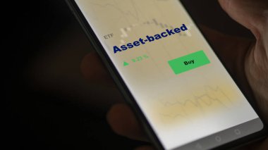 Bir yatırımcı ekranda aktif destekli etf fonunu analiz ediyor. Mal varlığının fiyatlarını gösteren bir telefon