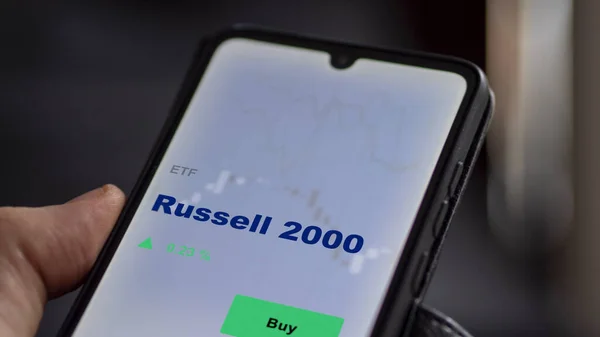 Bir yatırımcı, Russell 2000 EF fonunu ekranda analiz ediyor. Russell 2000 'in fiyatlarını gösteren bir telefon.