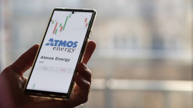 Bir değiş tokuş ekranında ATMOS Enerjisinin logosu. ATMOS Enerji Fiyat Hisseleri, Bir aygıt üzerinde $ATO.
