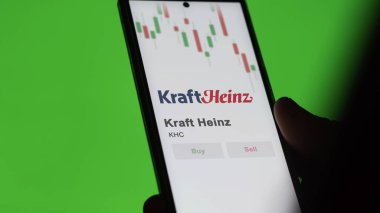 The logo of Kraft Heinz on the screen of an exchange. Kraft Heinz price stocks, $KHC on a device. clipart