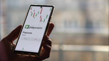 Takas ekranında Paycom 'un logosu. Paycom hisse senetleri, cihaza ödenen para.