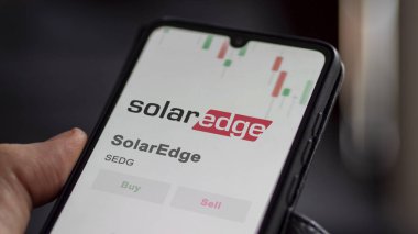 The logo of SolarEdge on the screen of an exchange. SolarEdge price stocks, $SEDG on a device. clipart