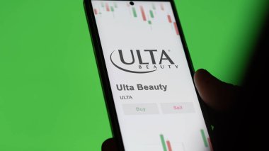 Ekrandaki Ulta Beauty logosu. Ulta Güzellik Fiyatı hisseleri, bir cihazda ULTA $.