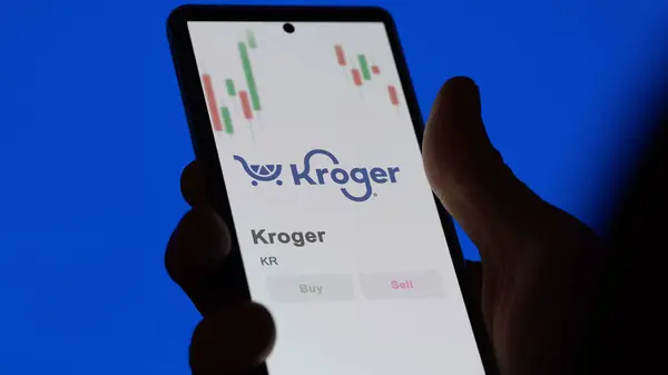 stock image The logo of Kroger on the screen of an exchange. Kroger price stocks, $KR on a device.