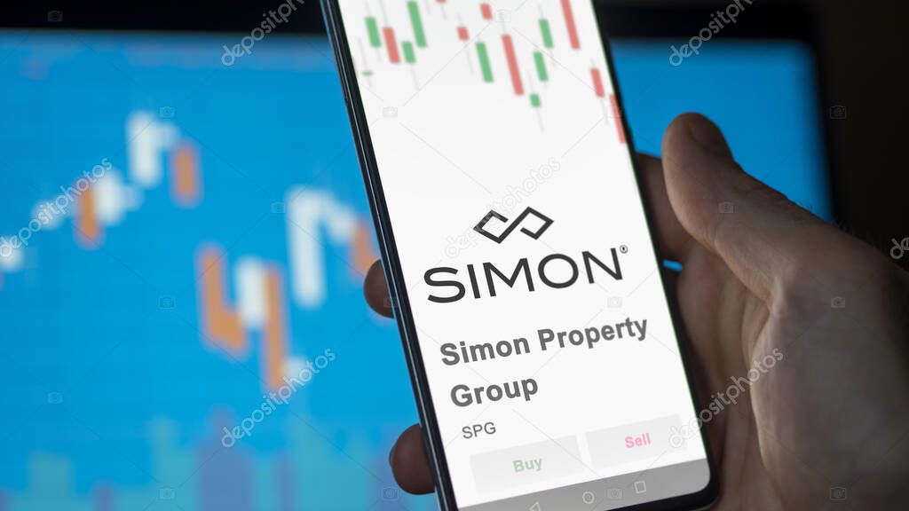 The logo of Simon Property Group on the screen of an exchange. Simon Property Group price stocks, $SPG on a device.