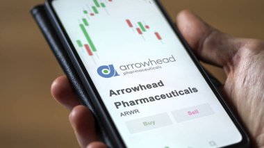The logo of Arrowhead pharmaceuticals on the screen of an exchange. Arrowhead pharma price stocks, $ARW on a device.