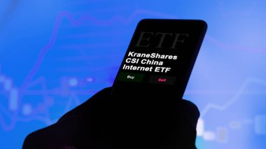 17 Kasım 2023. Bir yatırımcı telefondaki bir etf fonunu analiz ediyor KraneShares CSI China Internet ETF.