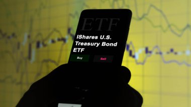 17 Kasım 2023. Bir yatırımcı telefonda bir etf fonu iShares U.S. Treases Bond ETF 'i analiz ediyor..