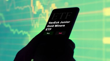 17 Kasım 2023. VanEck Altın Madencileri 'nin ETF fonunu telefonla analiz eden bir yatırımcı..