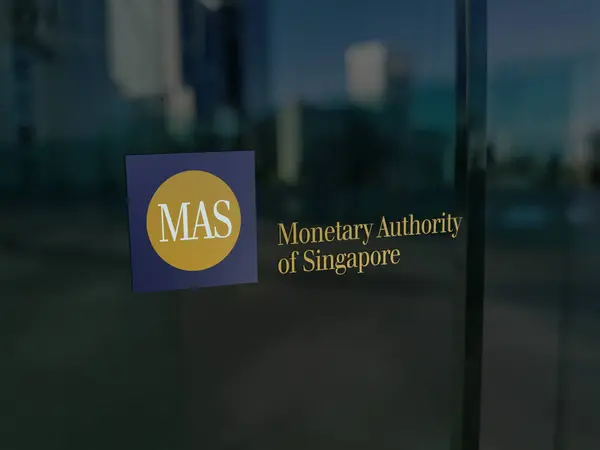 20 Ekim 2023. Singapur 'un MAS Parasal Otoritesi logosu yönetim masasının penceresinde..