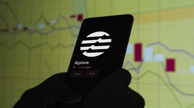 24 Kasım 2023. Aptos 'un bir telefondaki fiyatını analiz eden bir yatırımcı. Kripto takası için APT $' lık jeton para..