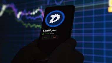 24 Kasım 2023. DigiByte 'ın bir telefondaki fiyatını analiz eden bir yatırımcı. Kripto takası için DGB $DGB..