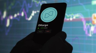 24 Kasım 2023. Telefondaki dKargo 'nun fiyatını analiz eden bir yatırımcı. Şifreli bir değiş tokuş için DKA dolar..