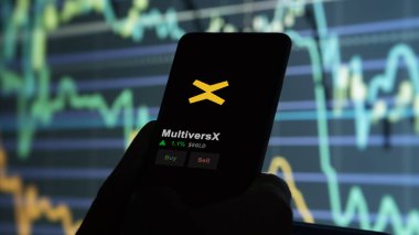 24 Kasım 2023. Bir telefondaki MultiversX 'in fiyatını analiz eden bir yatırımcı, kripto değiş tokuşunda EGLD $.
