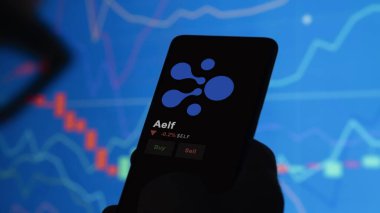 24 Kasım 2023. Telefondaki elf fiyatını analiz eden bir yatırımcı. Kripto değiş tokuşunda ELF doları..