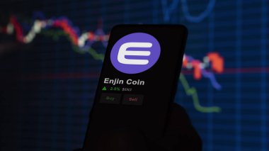 24 Kasım 2023. Telefondaki Enjin Coin 'in fiyatını analiz eden bir yatırımcı. Şifreli bir değiş tokuş için ENJ dolar..