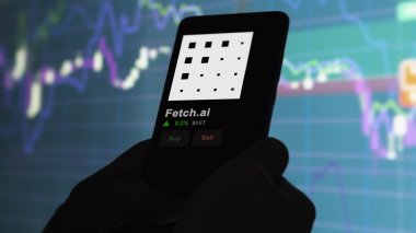 24 Kasım 2023. Telefondaki Fetch.ai 'nin fiyatını analiz eden bir yatırımcı. Şifreli bir değiş tokuş için FET $' lık bozuk para..