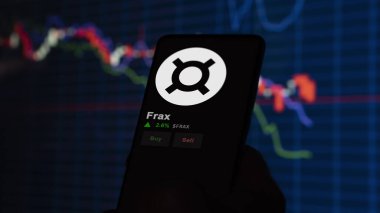 24 Kasım 2023. Frax 'in bir telefondaki fiyatını analiz eden bir yatırımcı. Kripto değiş tokuşunda FRAX dolar..