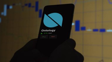 24 Kasım 2023. Telefondaki Ontolojinin fiyatını analiz eden bir yatırımcı. Kripto değiş tokuşunda ONT dolar..