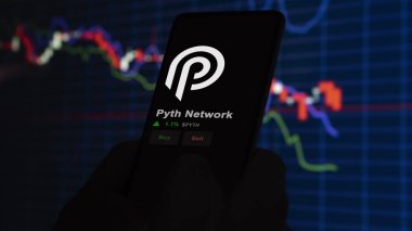 24 Kasım 2023. Pyth Network 'ün fiyatını telefondaki analiz eden bir yatırımcı. Kripto değiş tokuşunda PYTH dolar..