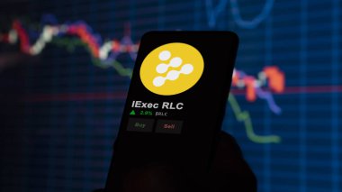 24 Kasım 2023. Bir telefondaki iExec RLC 'nin fiyatını analiz eden bir yatırımcı, kripto takası için RLC $.
