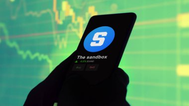 24 Kasım 2023. Telefondaki kum havuzunun fiyatını analiz eden bir yatırımcı. Kripto takası için kullanılan sahte para..