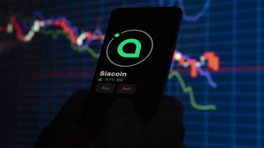 24 Kasım 2023. Telefondaki Siacoin 'in fiyatını analiz eden bir yatırımcı. Şifreli bir değiş tokuş için SC $' lık bozuk para..