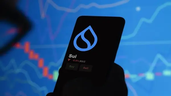 24 Kasım 2023. Telefondaki Sui 'nin fiyatını analiz eden bir yatırımcı, kripto takası için SUI $Jip..