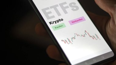 Aralık 2022. Bir yatırımcı telefon ekranındaki Kripto-ETF fonunu analiz eder. Almanca çeviri: Kaufen, Verkaufen, Krypto satın al, sat, şifreleme