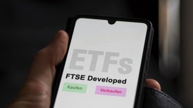 Aralık 2022. Bir yatırımcı, FTSE tarafından geliştirilen ETF fonunu telefon ekranı FTSE entwickelten 'da analiz eder. Almanca metin: Kaufen, Verkaufen, FTSE entwickelten Alış-Verişi, FTSE Geliştirilmiş