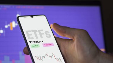 Aralık 2022. Bir yatırımcı, Xtrackers 'ın ETF fonunu telefon ekranında analiz eder. Almanca çeviri: Kaufen, Verkaufen: al, sat