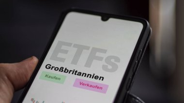 Bir yatırımcı telefon ekranı Grobritannien ETF 'de Büyük Britanya ETF fonunu analiz eder. Almanca çeviri: Kaufen, Verkaufen, Grobritannien satın al-sat, İngiltere.