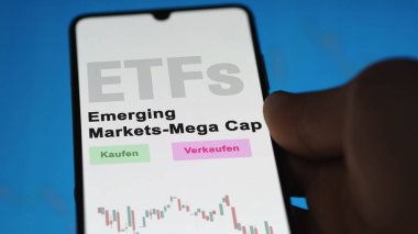 Aralık 2022. Bir yatırımcı Gelişmekte Olan Piyasalar Mega ETF fonunu telefon ekranında, Gelişmekte olan Piyasalar-Mega Cap-ETF 'lerde analiz eder. Almanca çeviri: Kaufen, Verkaufen, Gelişmekte Olan Piyasalar-Mega Cap Alım-Satım, Gelişmekte Olan Piyasalar Mega Cap