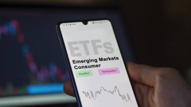 Aralık 2022. Bir yatırımcı, Gelişmekte Olan Piyasa Tüketicileri ETF fonunu telefon ekranında Gelişmekte olan Piyasalar Tüketicisi-ETF 'lerde analiz eder. Almanca çeviri: Kaufen, Verkaufen, Gelişmekte olan Piyasa Tüketicileri, Yükselen Piyasa Tüketicileri