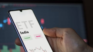 Etf fonunu analiz eden bir yatırımcı. İspanyolca ETF metni: Hindistan, satın al, sat.